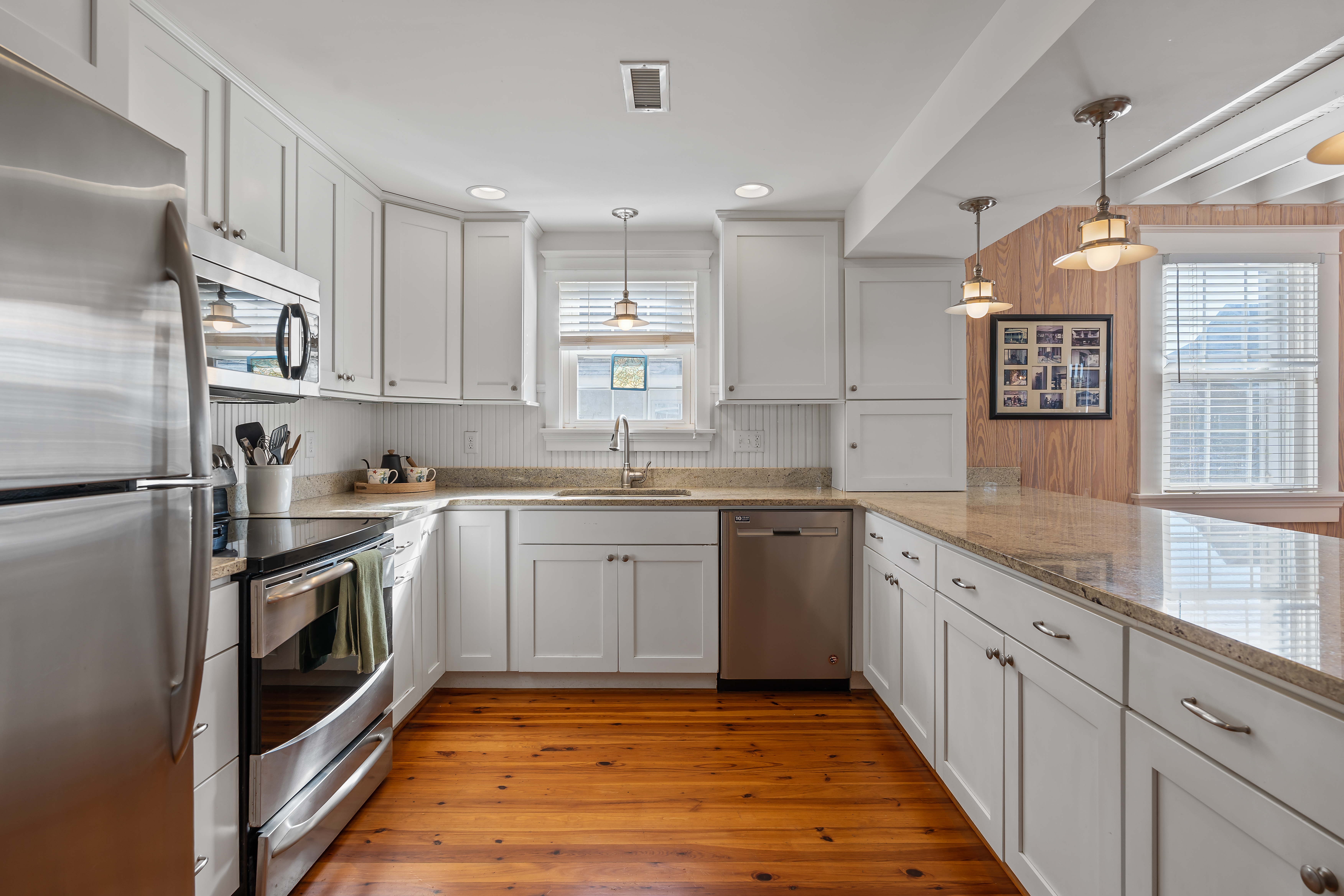 The kitchen with stainless appliances and long granite counters
